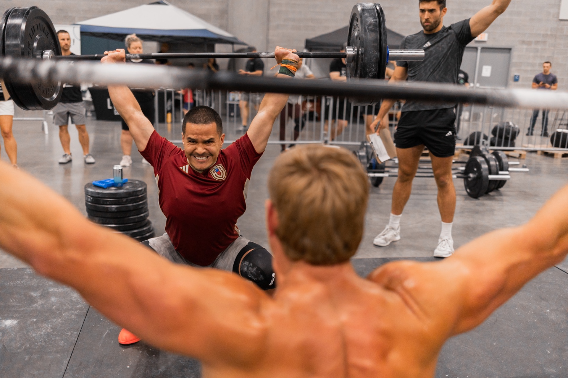 Athlete locking out a barbell snatch at a competition