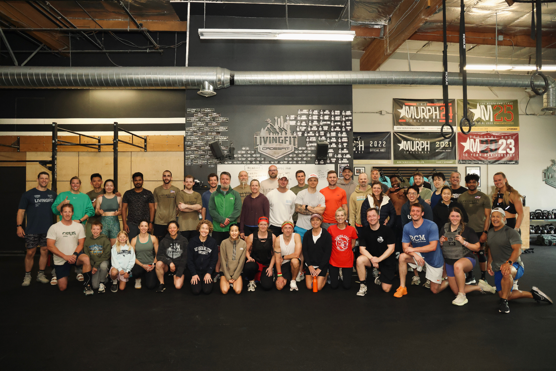 LivingFit CrossFit community group photo in front of the Murph wall