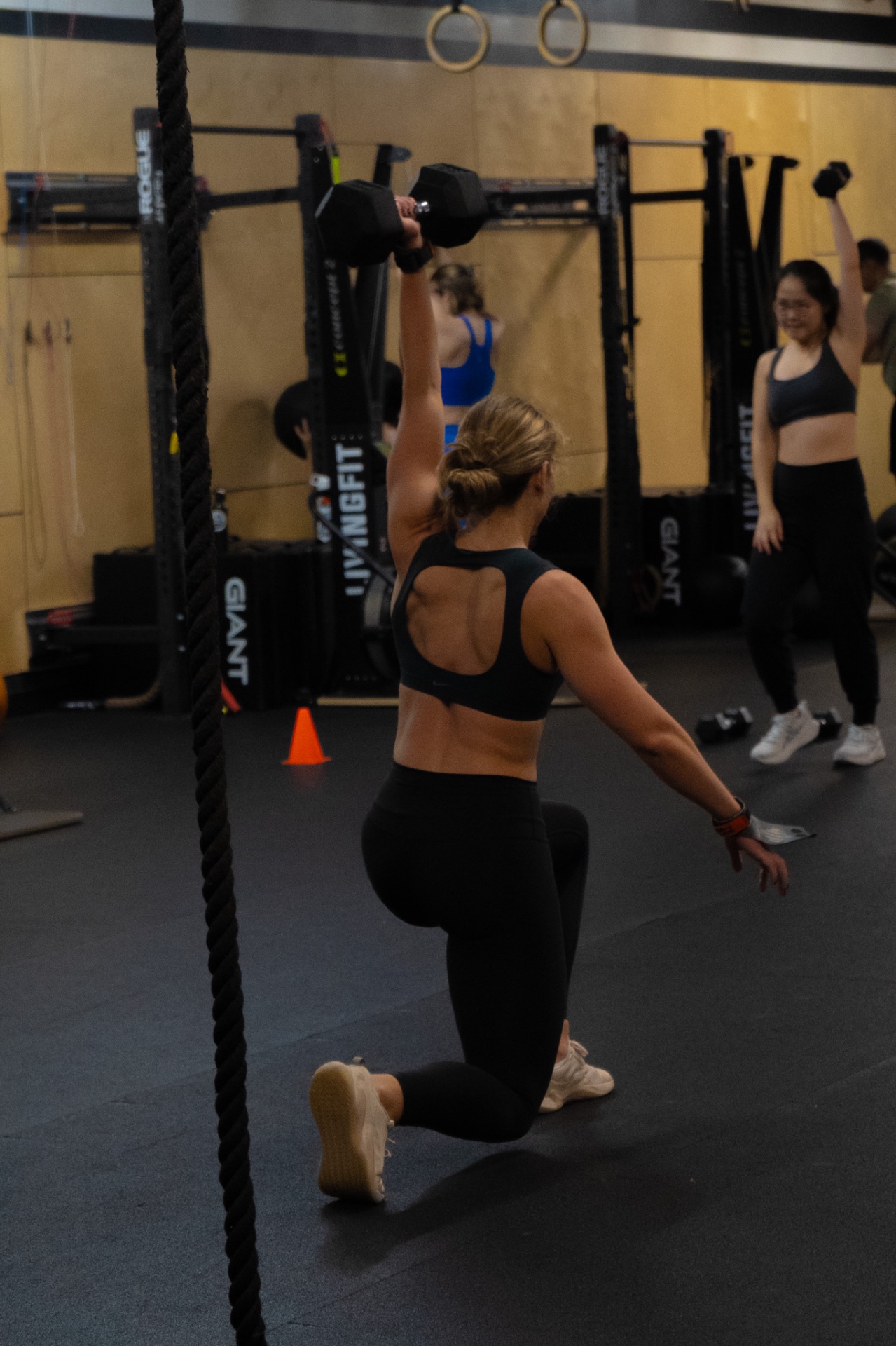 Member performing a single-arm dumbbell snatch at LivingFit